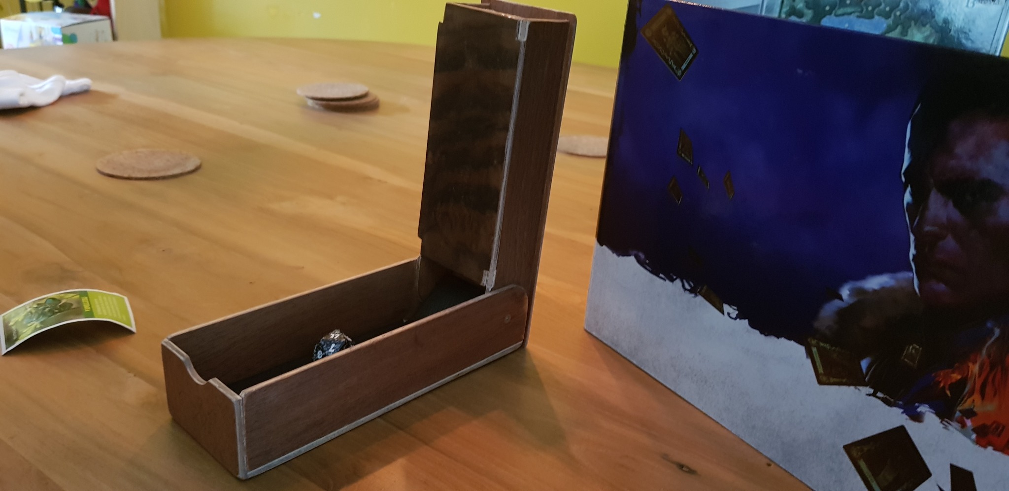 a wooden dice tower standing on a table, opened