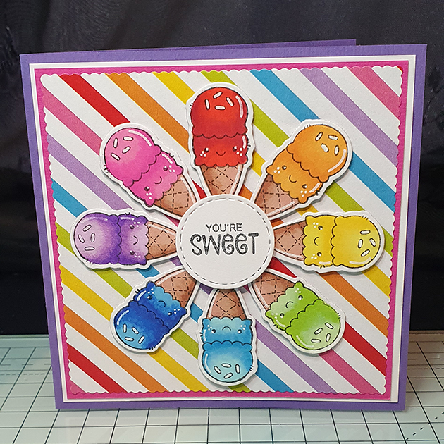 A square card with a striped rainbow background. Ice creams in each colour of the rainbow circle around the center. In the center is a small white circle that reads You're Sweet!